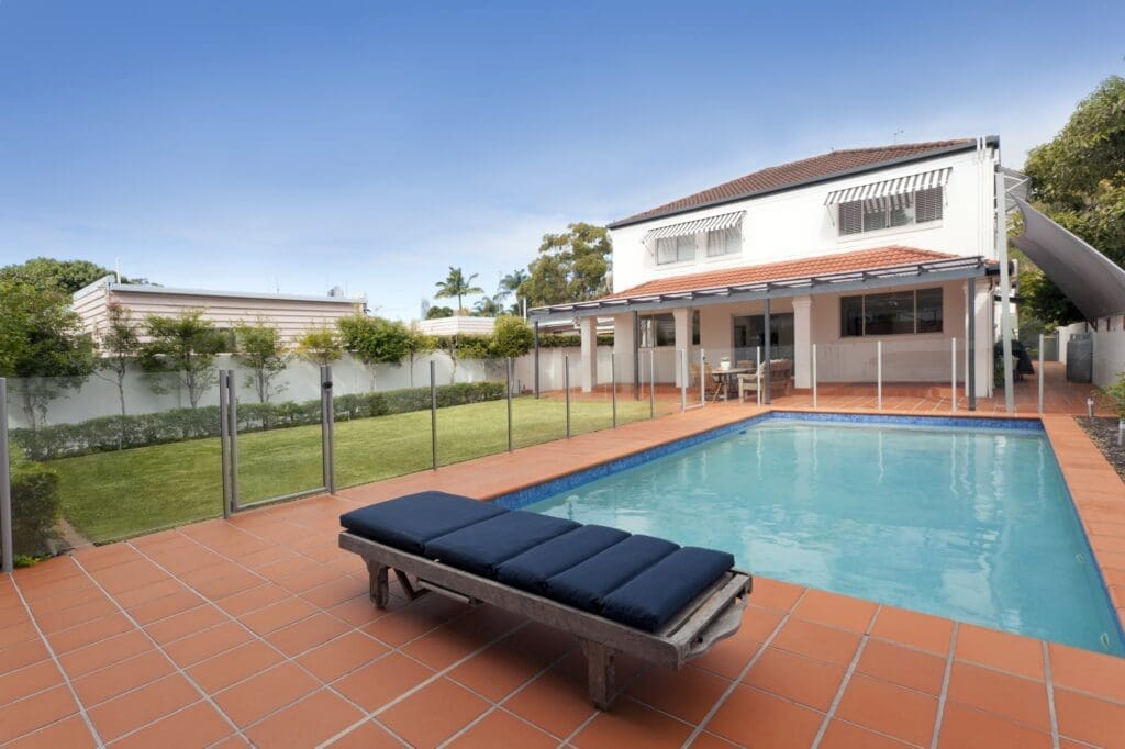 Suburban house backyard with pool and lounger